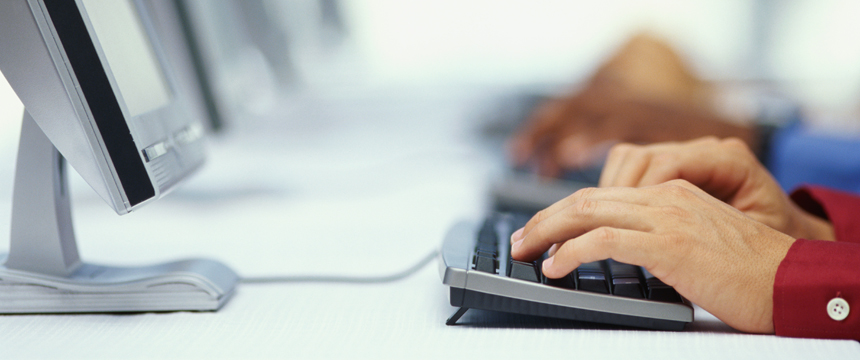 Hands typing on keyboard of computer